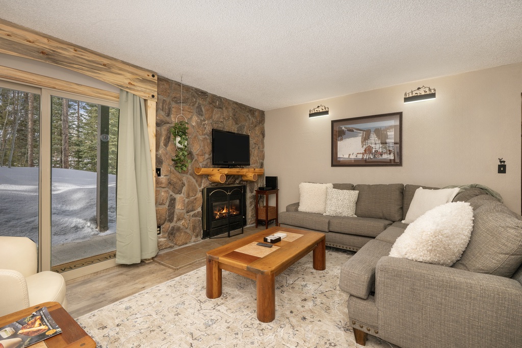 Cozy up in your alpine retreat where the stone fireplace crackles warmly and plush seating invites relaxation after snowy mountain adventures.