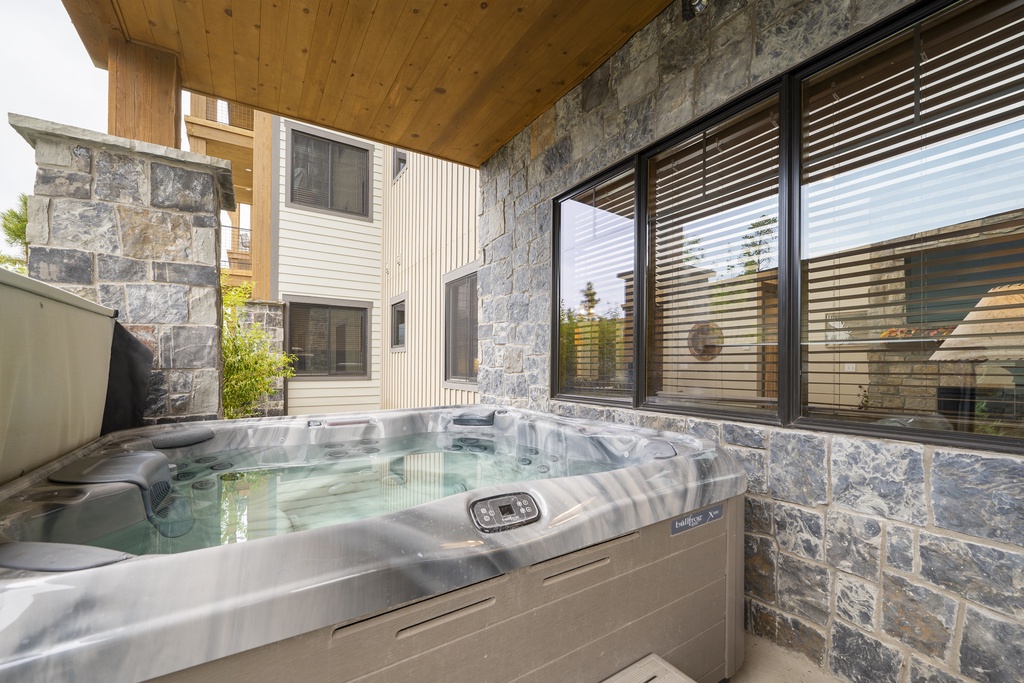 Soak your worries away in your private hot tub, surrounded by natural stone walls and mountain views through expansive windows.