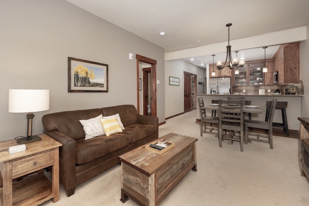 Relax in your spacious living room with rich leather seating and rustic wood accents, seamlessly connected to your fully equipped kitchen.