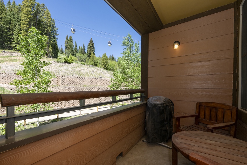 Unwind on your private balcony with sweeping mountain and forest views, where a cozy seating area invites you to soak in the fresh alpine air and watch the gondolas glide by overhead.