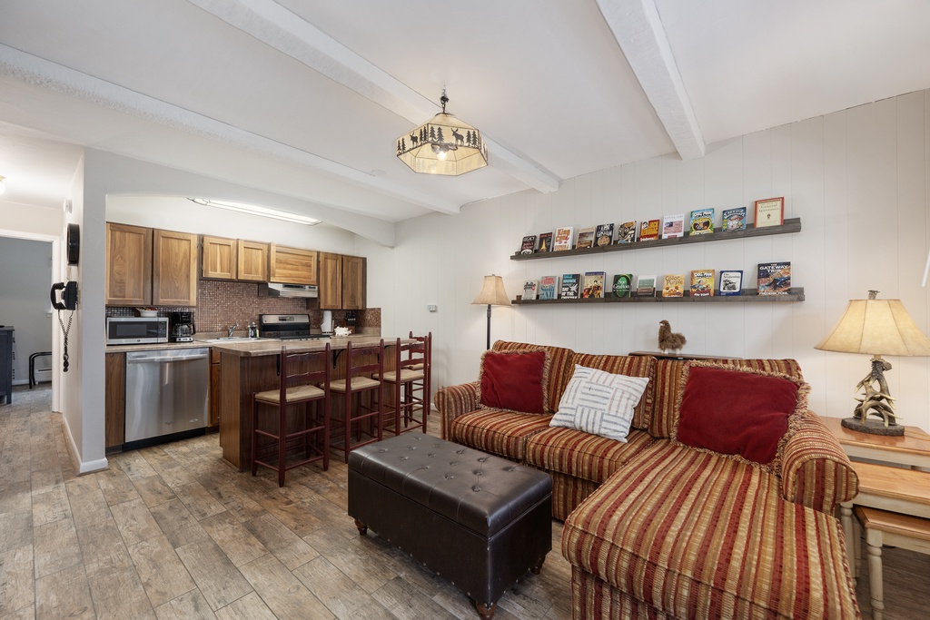 Relax in your cozy living space with plush striped seating, browse the curated book collection, and enjoy the fully equipped kitchen.