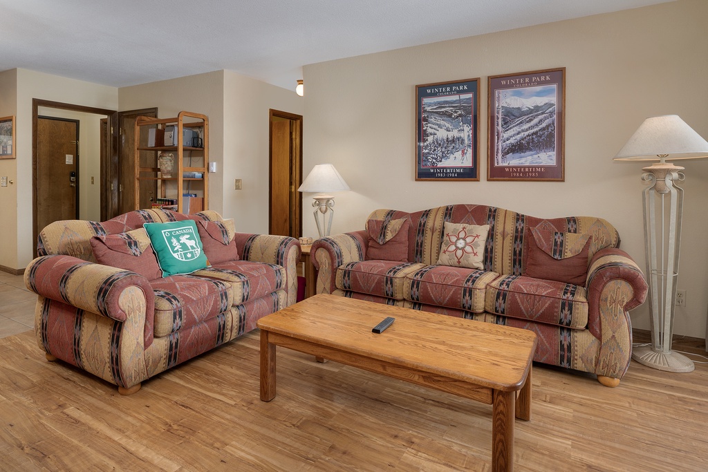 Sink into cozy sofas with ski lodge charm, where warm lighting and mountain artwork create your perfect après-ski retreat.