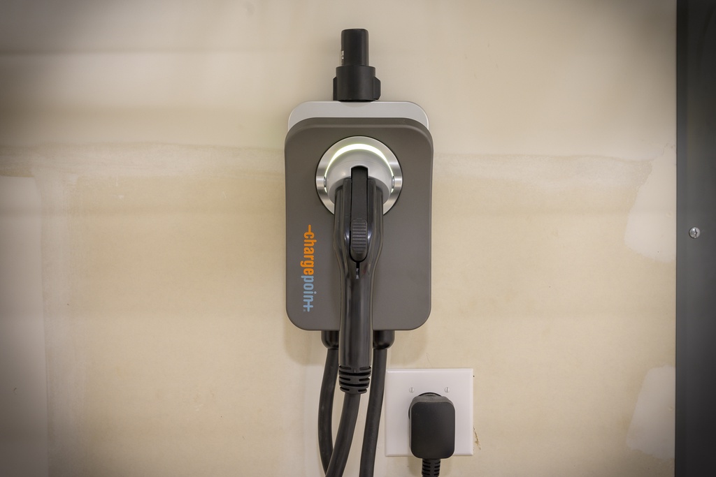 An EV charging station is mounted on the wall, ready to power your electric vehicle during your stay with convenient on-site charging access.