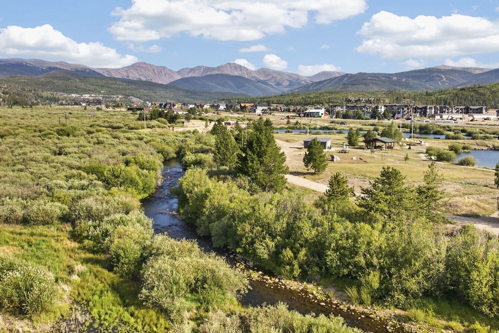 Aerial view showing the property's mountain setting, with a winding river through natural landscape and residential development in the surrounding area.