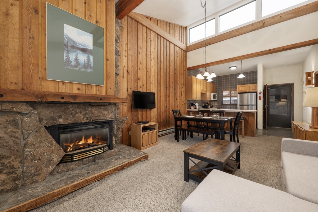 Cozy up by your crackling stone fireplace in this warm living space, where vaulted ceilings and rustic wood create the perfect mountain retreat.