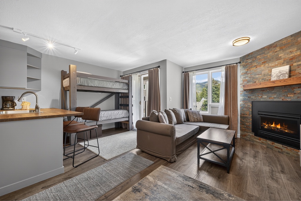 Unwind in your cozy living space featuring a warm fireplace, mountain views, and comfortable seating—perfect for family relaxation after adventurous days exploring the area.