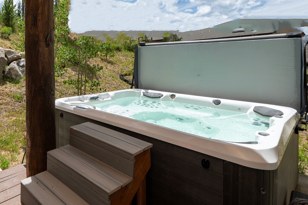 Soak away your cares in the bubbling hot tub, surrounded by natural hillside views—your perfect outdoor retreat awaits.