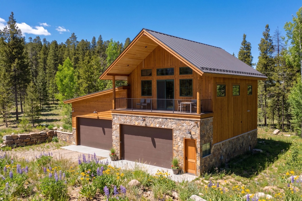 A handsome mountain retreat awaits, with natural wood siding and stone accents that blend beautifully into the forested landscape. The spacious deck invites you to soak in fresh alpine air and sunshine.