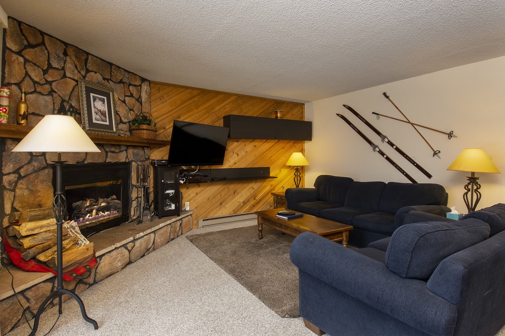 Cozy up by the stone fireplace after your mountain adventures, with comfortable seating and rustic charm throughout.