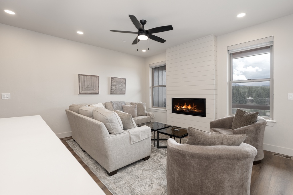 Unwind in your elegant living room, where plush seating surrounds a cozy fireplace and natural light creates the perfect retreat.