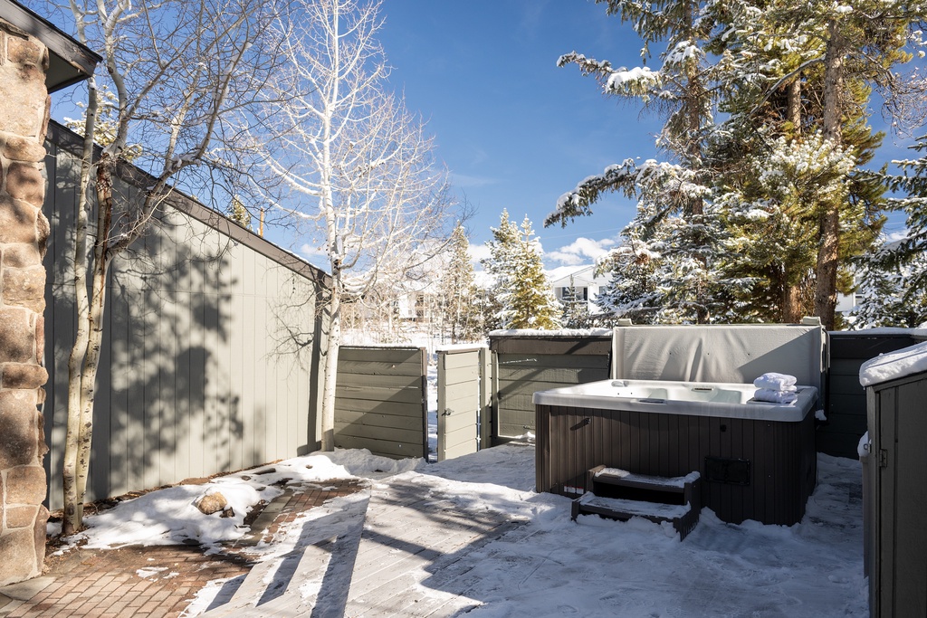 Soak in your private hot tub surrounded by snow-dusted evergreens and crisp winter air in this secluded outdoor retreat.