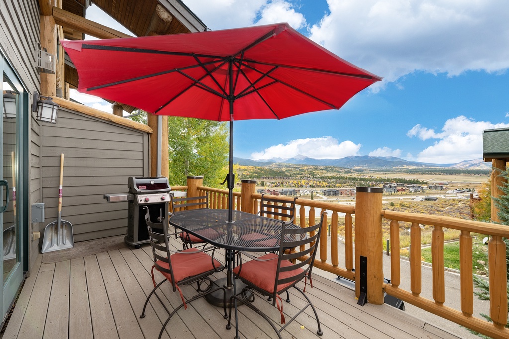 Your private deck offers stunning mountain views while you grill and dine al fresco under the red umbrella's shade.