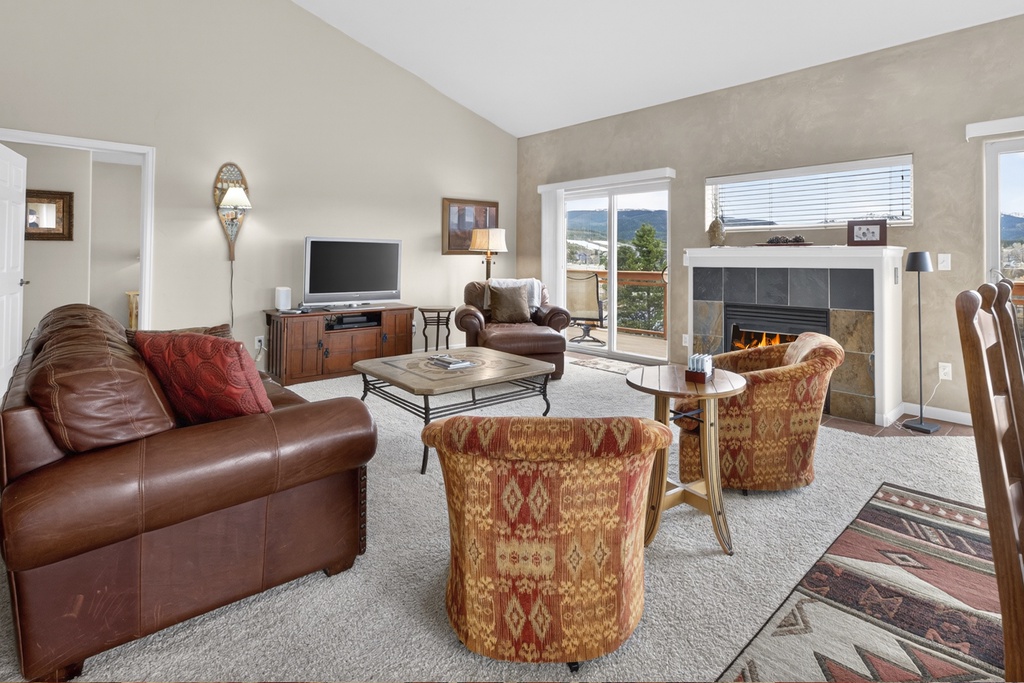 Unwind in your spacious living room with leather seating, crackling fireplace, and mountain views through large windows.