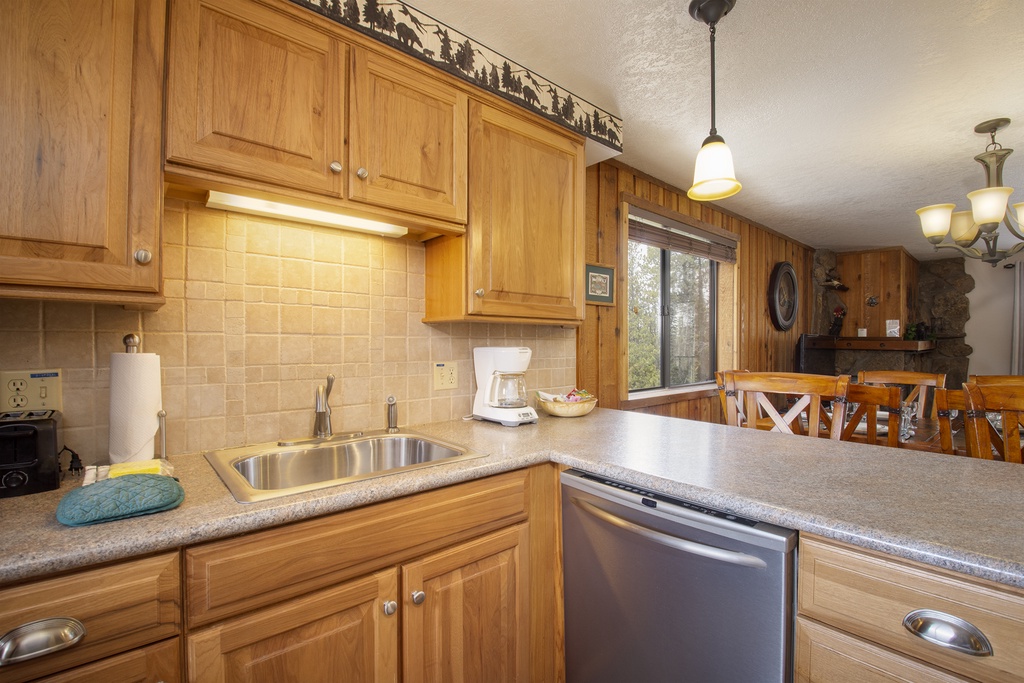 Your fully equipped kitchen features warm wood cabinets, granite countertops, and stainless steel appliances, creating the perfect space for preparing meals during your stay.