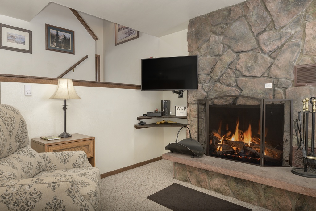 Cozy up by your crackling stone fireplace while watching TV from your comfortable chair in this warm living space.
