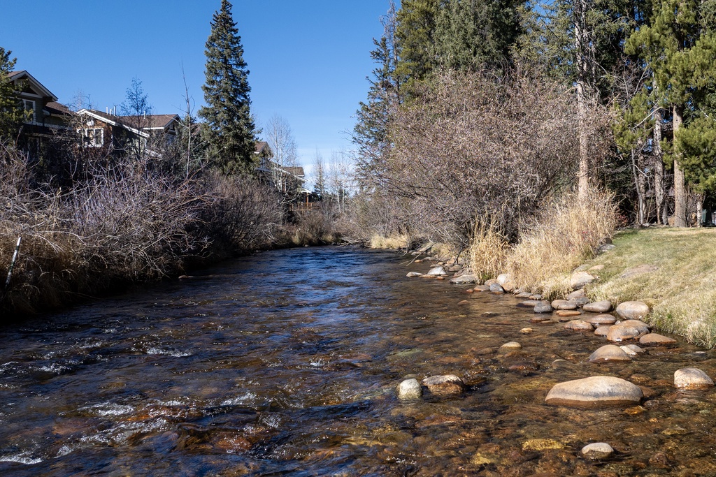 A peaceful river flows through the neighborhood, creating a tranquil setting with natural beauty and residential charm.