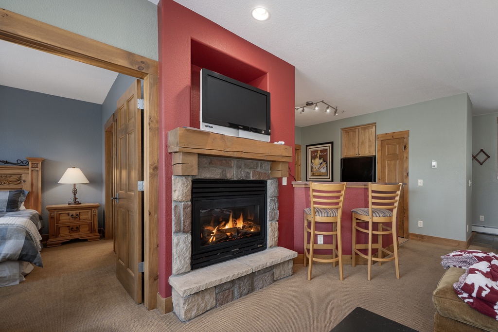 Cozy up beside your crackling stone fireplace while watching TV, creating perfect mountain cabin evenings in your comfortable retreat.