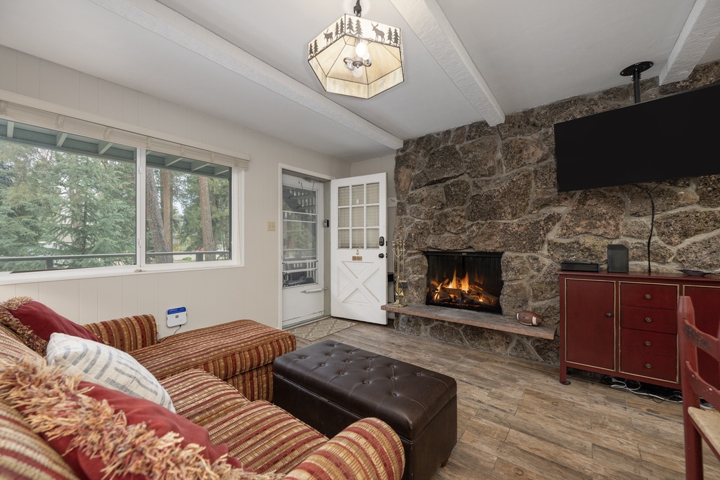 Cozy up by your crackling stone fireplace while forest views frame your mountain retreat through picture windows.