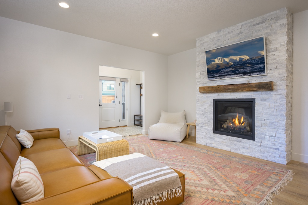 Unwind in your bright living room where a cozy fireplace and mountain artwork create the perfect retreat for relaxing evenings after your alpine adventures.