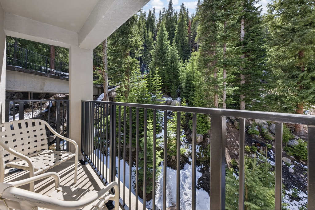 Unwind on your private balcony overlooking a serene forest of evergreens and rocky terrain, where fresh mountain air and natural beauty create your perfect retreat.