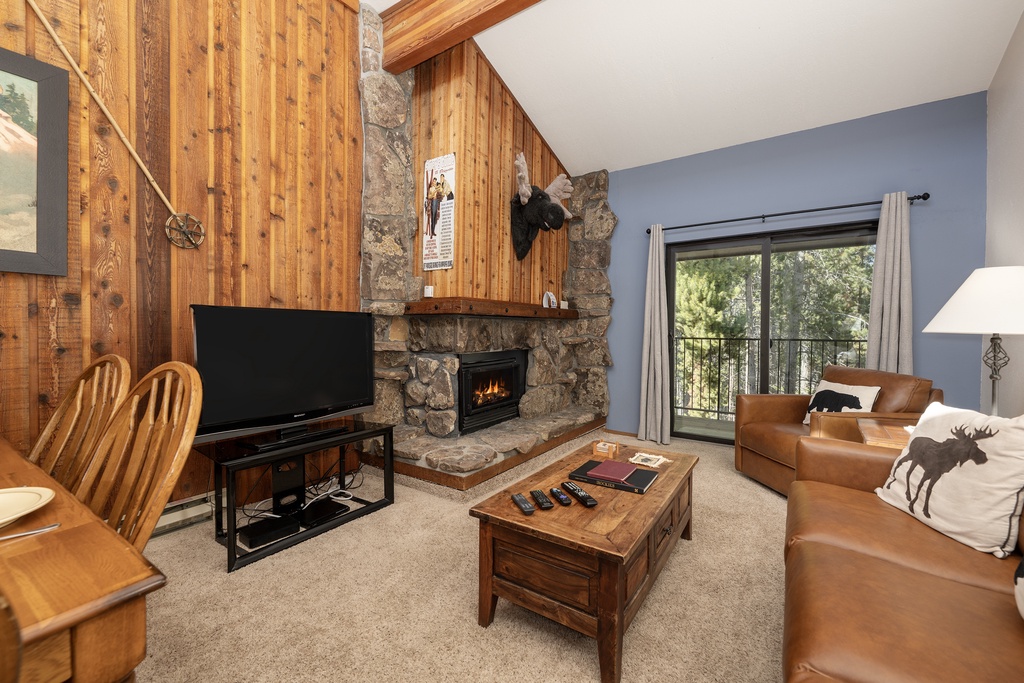 Cozy up in your mountain retreat with rustic wood walls, a crackling stone fireplace, and leather seating perfect for relaxing evenings.