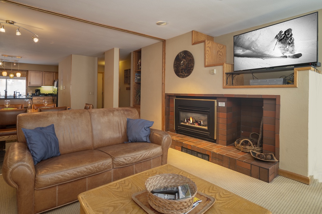 Cozy up by your fireplace with leather seating, watch skiing adventures on the mounted TV, and enjoy the open kitchen for perfect mountain evenings.