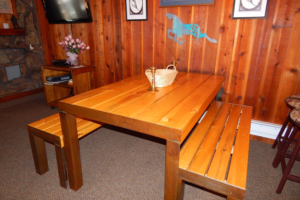 Gather around your rustic dining table where warm wood meets cozy cabin charm, perfect for sharing meals and making memories together.