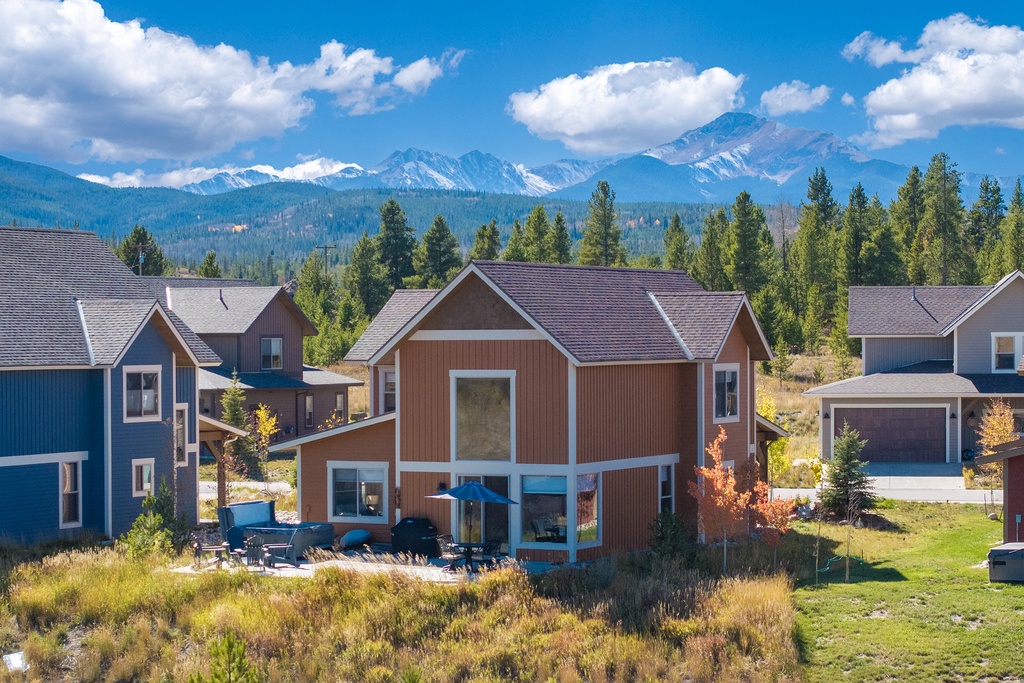 Mountain retreat featuring modern cabins set against dramatic alpine peaks and forest landscape.