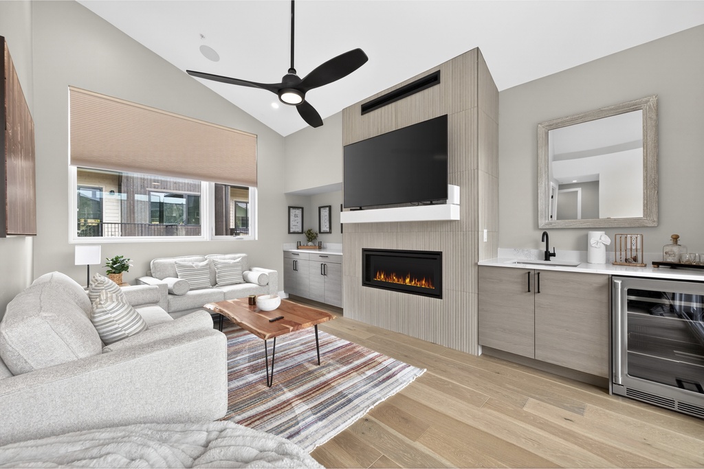 Sink into comfort in your stylish living space featuring a cozy fireplace and modern kitchen perfect for relaxing evenings.