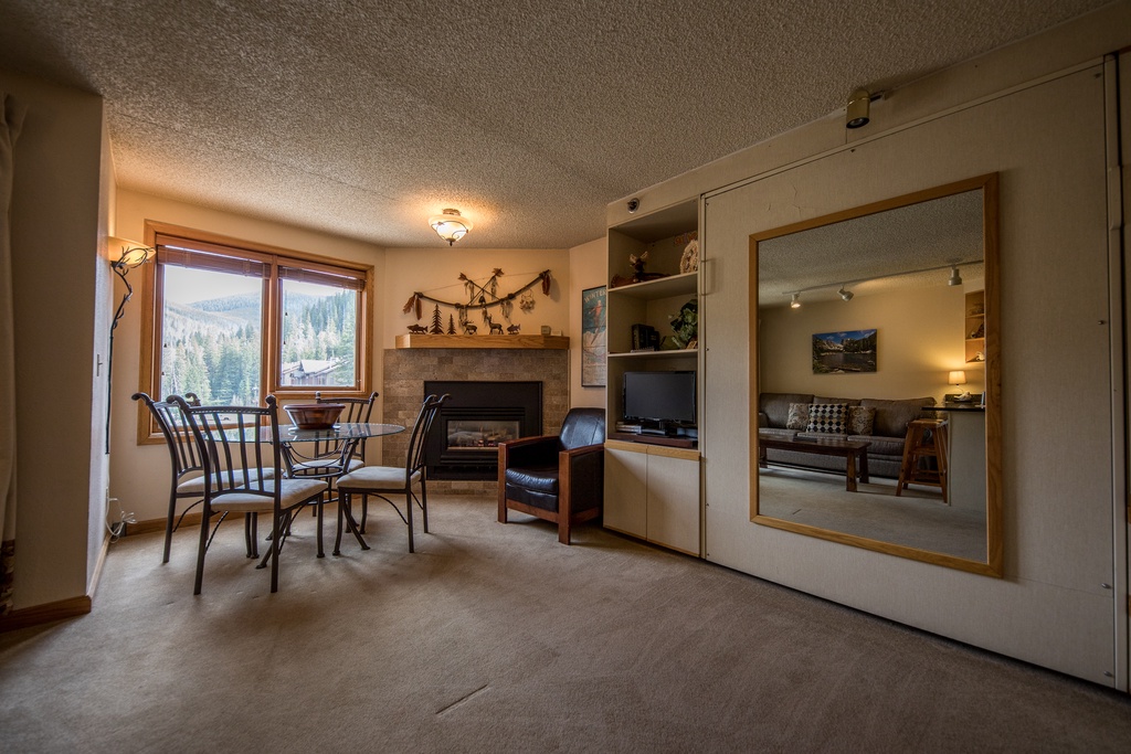 Relax in your cozy mountain retreat with stunning forest views, featuring a warm fireplace, dining nook, and entertaining space.