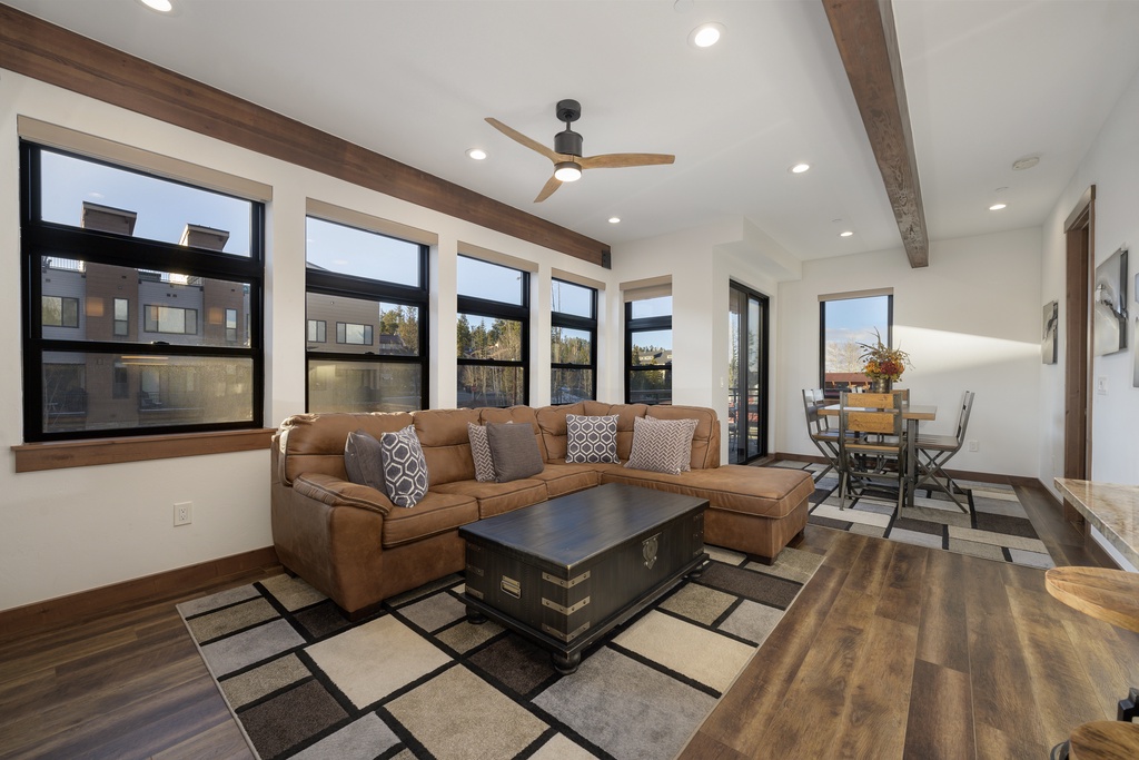 Sink into your plush sectional sofa while enjoying mountain views through expansive windows in this bright, modern living space.