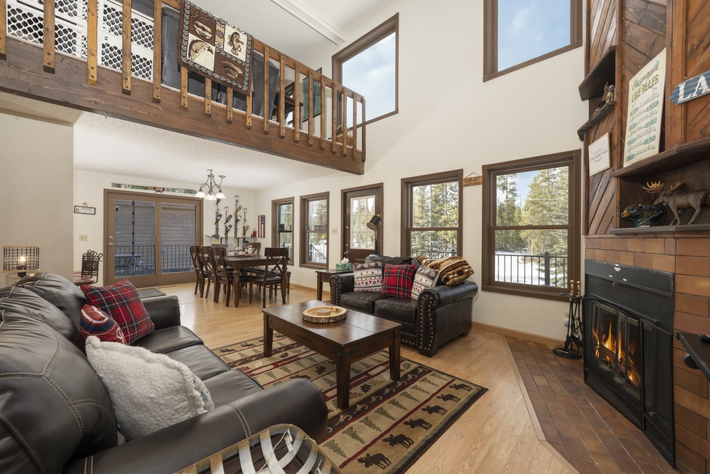 Cozy up in your mountain-style living room with leather sofas, crackling fireplace, and soaring ceilings overlooking wooded views.