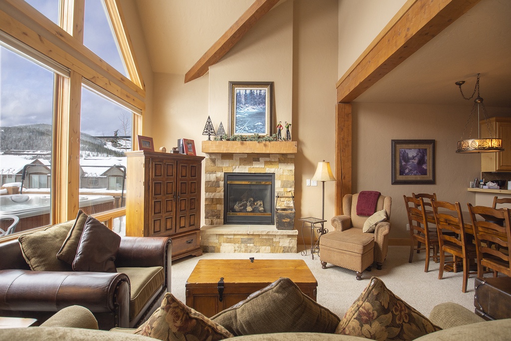Gather around the stone fireplace in this cozy living space, where exposed beams and mountain views create your perfect alpine retreat.