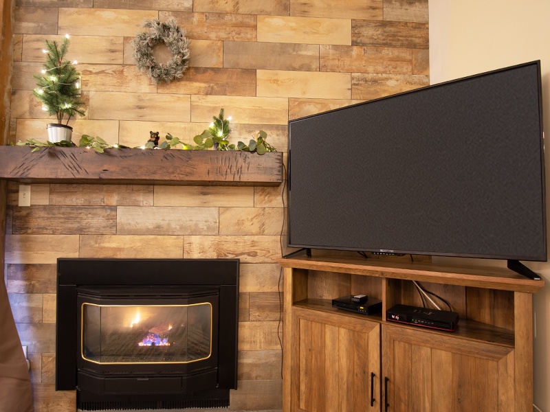Cozy up by your private fireplace while catching up on shows—this warm living space features rustic wood accents and modern comfort.