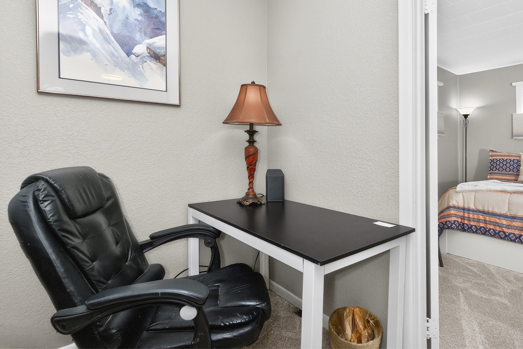 A quiet corner awaits your thoughts—settle into the plush chair and let work or reflection flow naturally at your private desk.