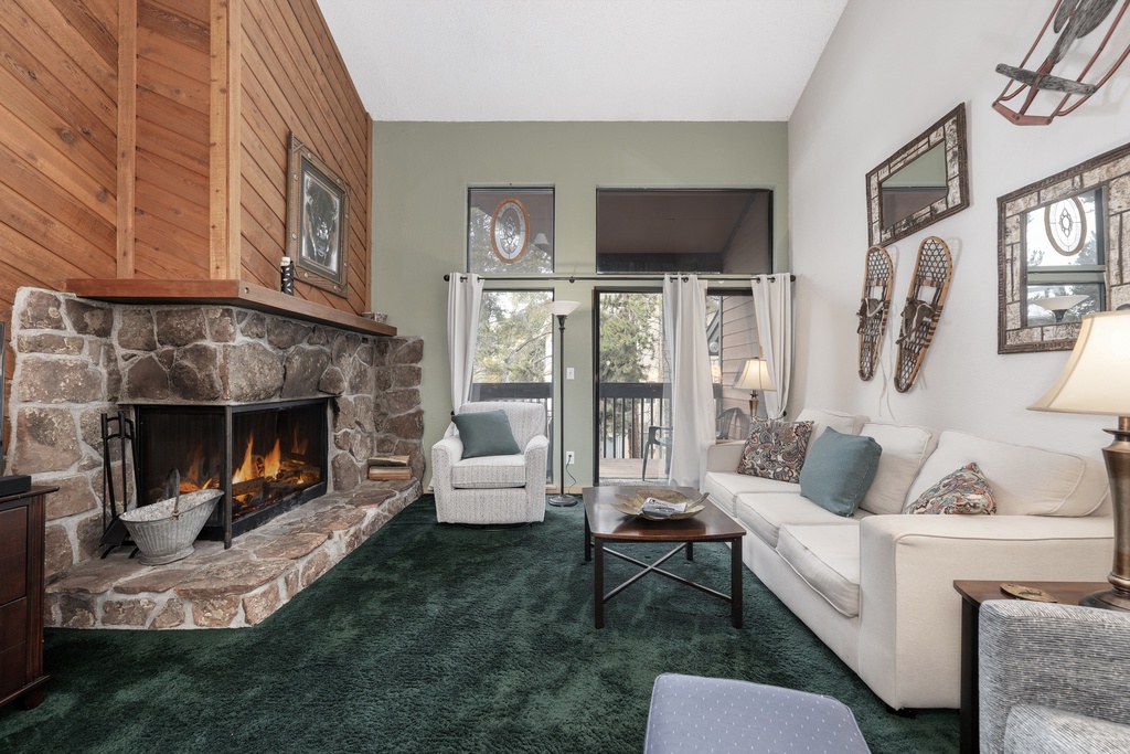 Cozy up by your crackling stone fireplace as warm wood accents and plush seating create the perfect mountain retreat atmosphere.