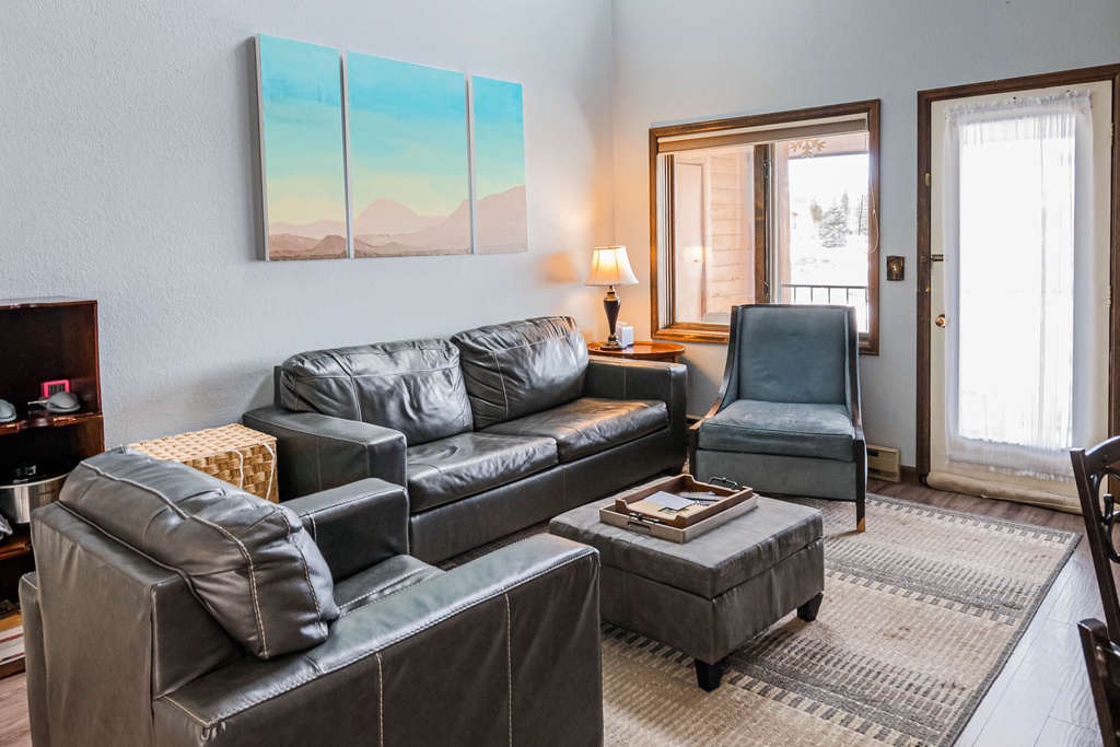 Unwind in this bright living space with soaring ceilings, cozy leather seating, and warm natural light streaming through skylights.
