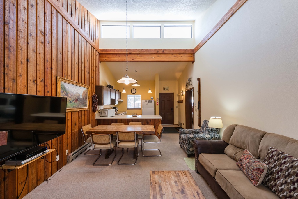 Unwind in your cozy retreat with soaring ceilings, warm wood accents, and a perfect blend of living, dining, and kitchen spaces for memorable moments.