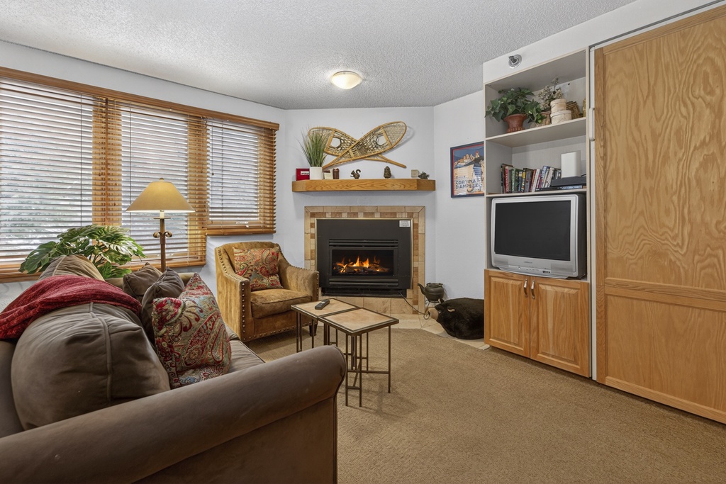Curl up in your cozy living room with plush seating, a warm fireplace, and entertainment center—perfect for relaxing evenings after mountain adventures.