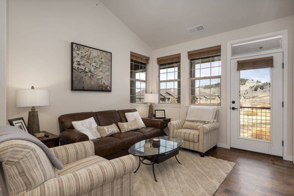 Settle into your cozy living space with plush seating and stunning mountain vistas through oversized windows.
