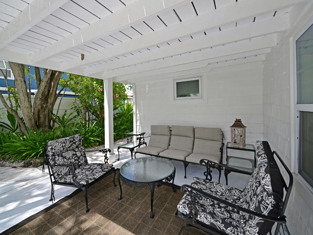 Relax in your private covered patio, where elegant seating invites afternoon conversations beneath stylish latticed shade.