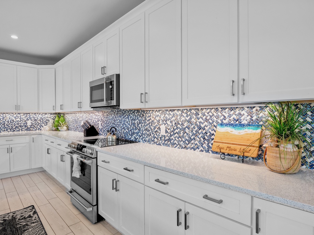 Fully equipped kitchen features white cabinets