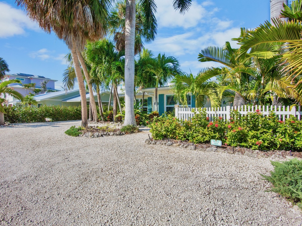 Tropical paradise setting with swaying palm trees and lush landscaping surrounding the colorful beach property