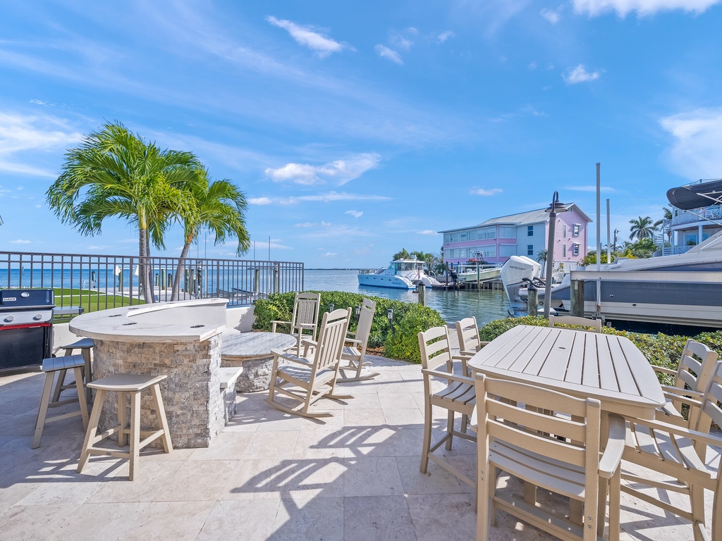 Waterfront patio with canal views, outdoor dining, and BBQ