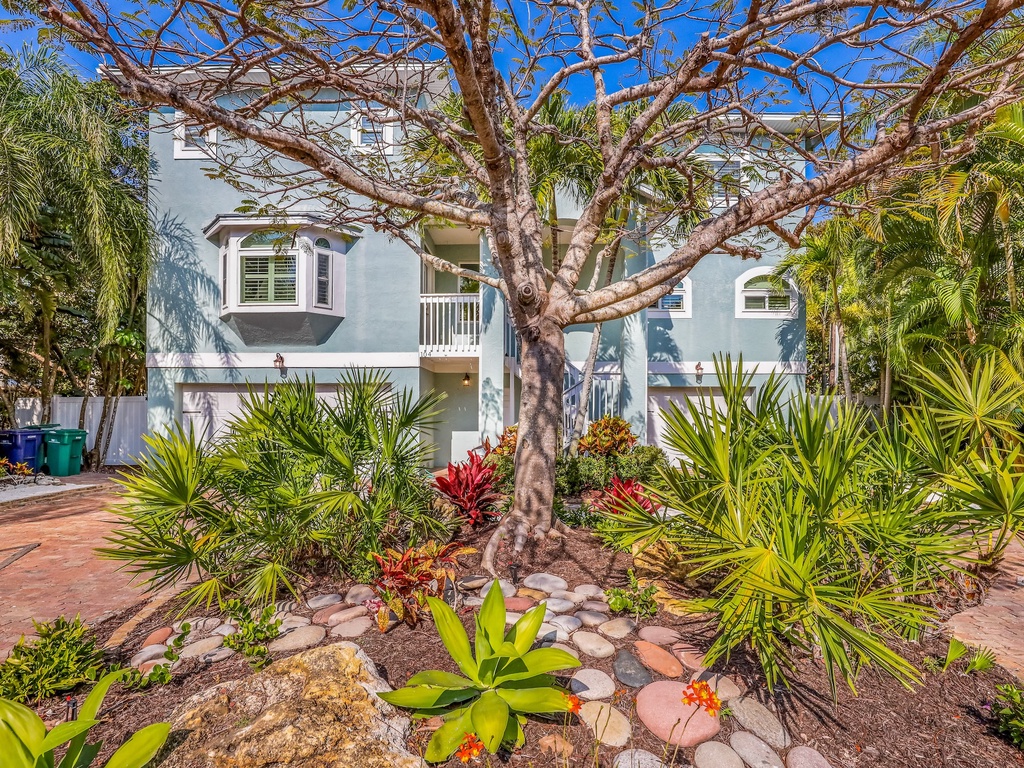 Beautiful tropical property with lush landscaping and mature shade trees creating a serene island atmosphere.