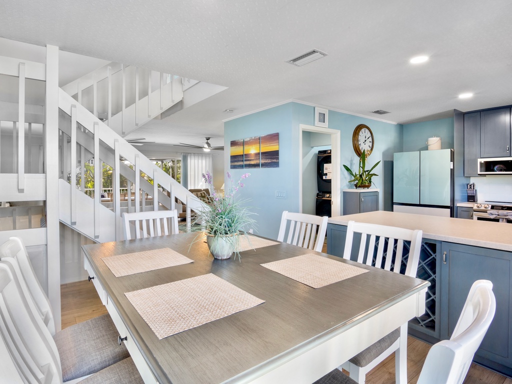 Your open-concept kitchen and dining space features modern blue cabinetry, stainless appliances, and a welcoming dining table for memorable meals.