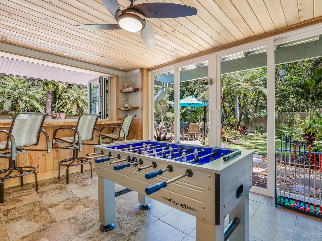 Challenge friends to foosball while enjoying tropical garden views in your covered game room retreat.
