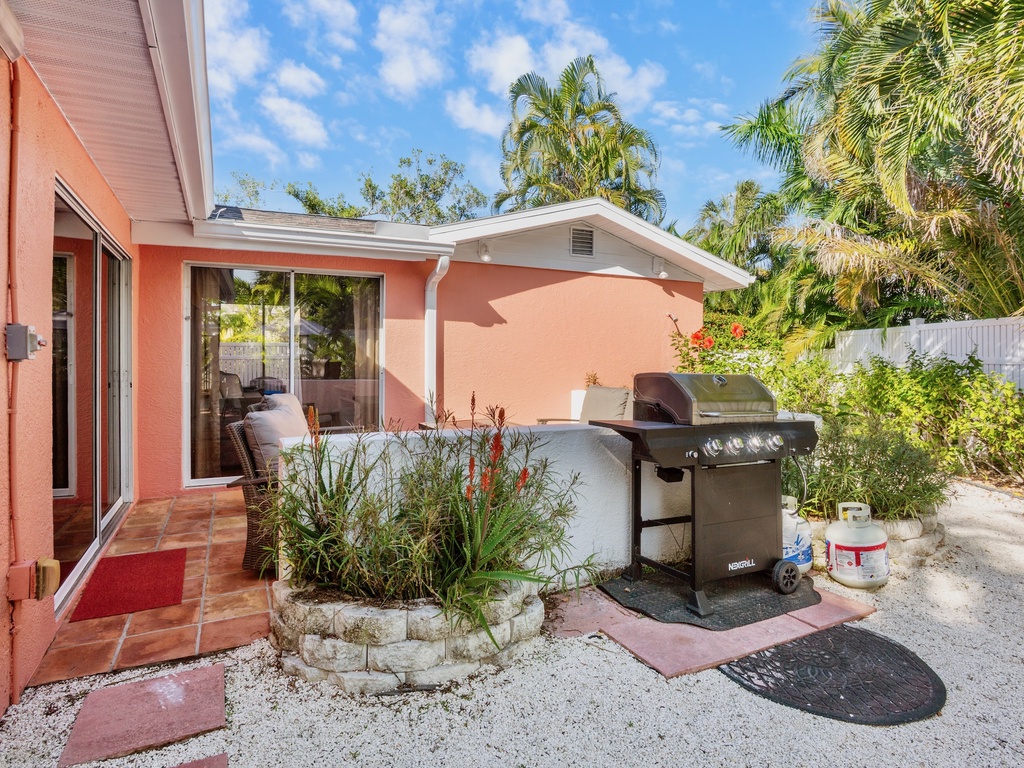 BBQ grill surrounded by lush palms