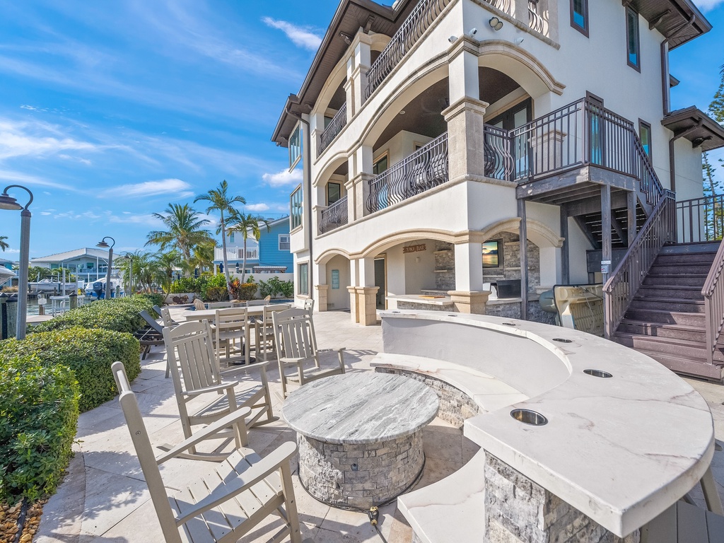 Multiple balconies, palm trees, and outdoor entertaining spaces.