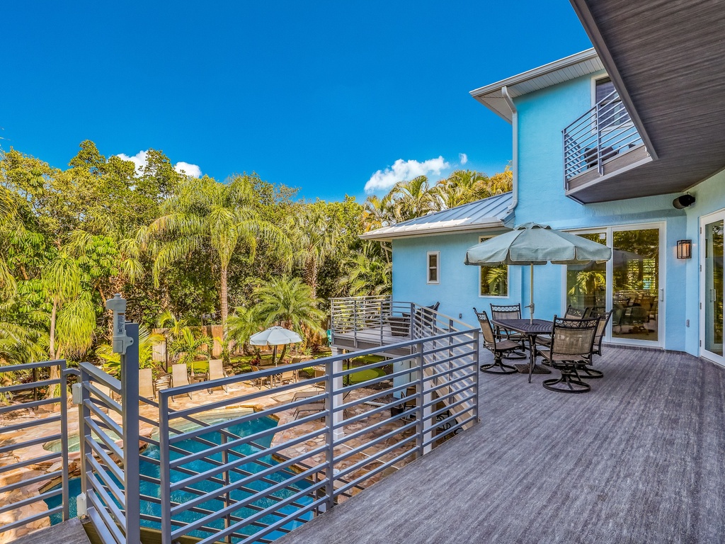 Spacious deck overlooks tropical gardens and pool, perfect for morning coffee or sunset dining with panoramic views.